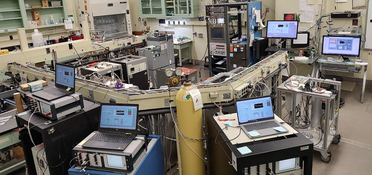 Laboratoř NIST s teplotními lázněmi, měřicími můstky, referenčními odpory a počítači pro kalibraci platinových teploměrů.